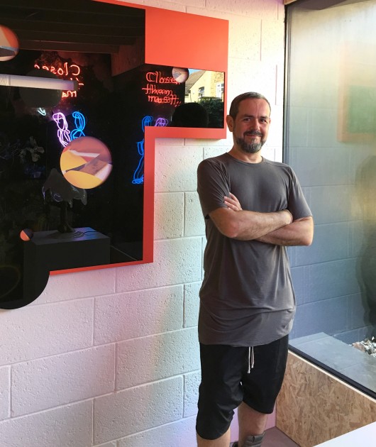 Victor Benady in front of a digital print by Kate Steciw. Photo: J.Ramon Fernandez. Courtesy of Victor Benady.