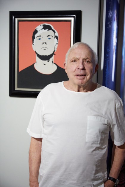 Richard Ekstract in front of their most treasured artwork: Andy Warhol, Self-Portrait, 1964. Courtesy of Eileen and Richard Ekstract.