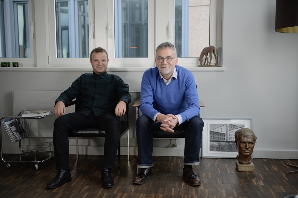 Unnamed 60s chProf. Dr. Rzany and his curator, Hani el Hurt, in unnamed 60s chairs, with Yaysutake Kojma photography from the urban Berlin series (2015), plaster portrait of Walter Jüngst (one of the Prof. Dr. Rzany’s favourite), on the window a small foal from Else Bach. Courtesy of Prof. Dr. Berthold Rzany.airs, Yaysutake Kojma photography from the urban Berlin series (2015), plaster portrait of Walter Jüngst (one of the Prof. Dr. Rzany’s favourite), on the window a small foal from Else Bach. Courtesy of Prof. Dr. Berthold Rzany.