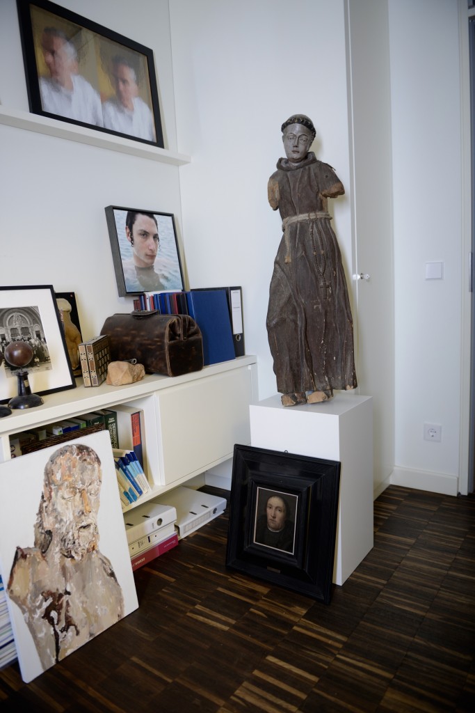 Frontal view from Prof. Dr. Rzany's desk. Standing on a pedestal a statue of St. Anthony (Italian/Spanish from the 16th century), below a portrait of a protestant parson from the 16th century. On the wall a double portrait of myself from his artist friends, Renata Stih and Frieder Schnock, below a portrait photo of Benyamin Reich. Courtesy of Prof. Dr. Berthold Rzany.