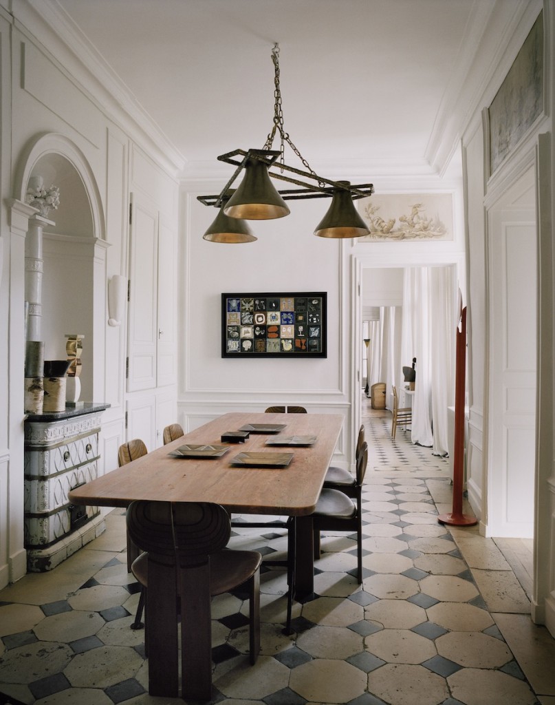 Ispahan table in Iranian travertine and Archipel chandelier by Charles Zana, set of dishes in raw metal by Enzo Mari, chairs by Afra and Tobia Scarpa, vases by Andrea Branzi, wall work by Bruno Capacci, Élysée floor lamp by Pierre Paulin. Photo: François Halard. Courtesy of Charles Zana