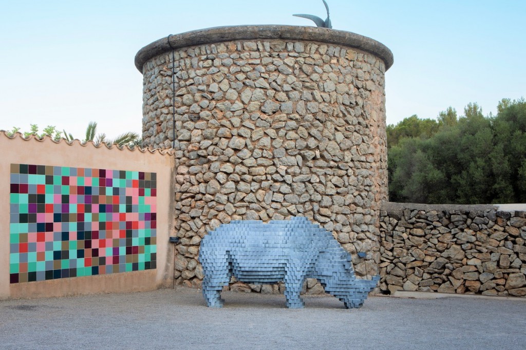 Rhino Cubist, 2021, a pixelated, three dimensional rhino in bronze, exhibited at the sculpture park in front of the mosaic Aperiodic Landscape, 2007, an interpretation of a photograph of the rose garden pergola in spring with the evocation of a geometric flowered wall, both works by Ben Jakober / Yannick Vu. Photo: Francisco Ubilla